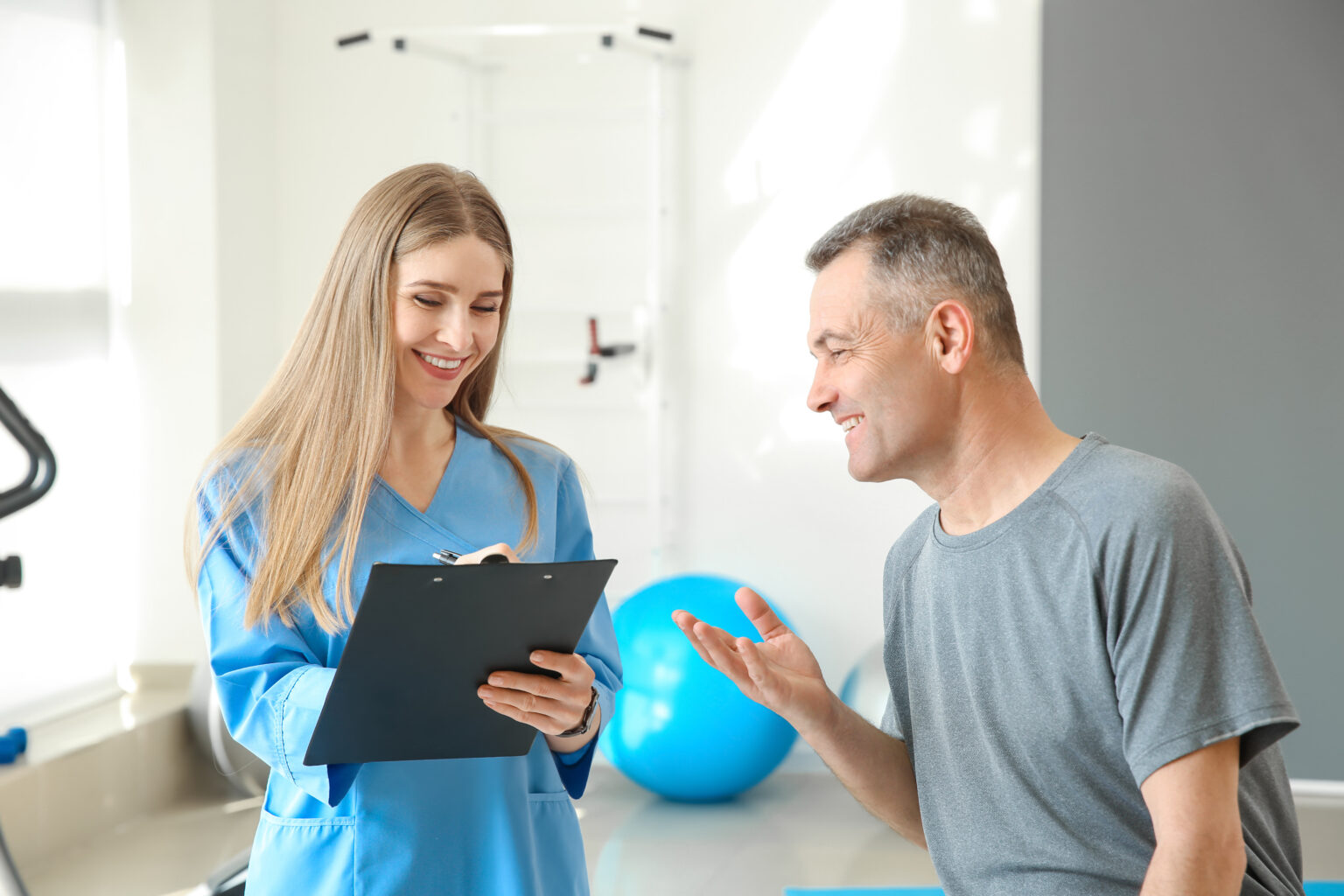 Physiotherapist working with mature patient in rehabilitation center