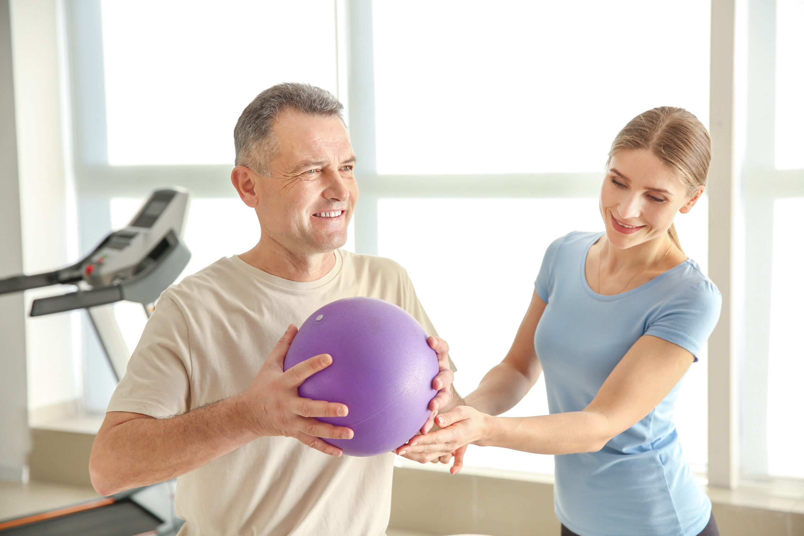 Physiotherapist working with mature patient in rehabilitation center