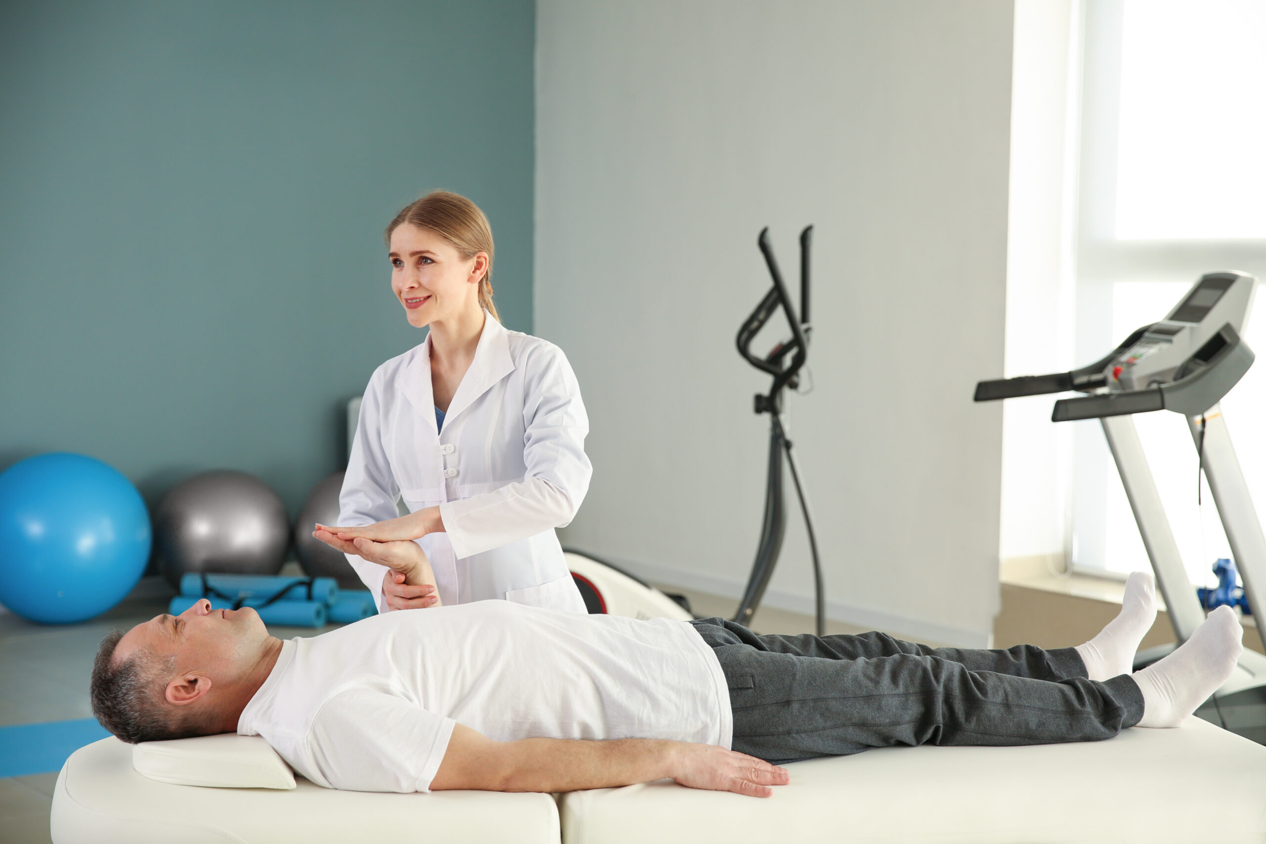 Physiotherapist working with mature patient in rehabilitation center